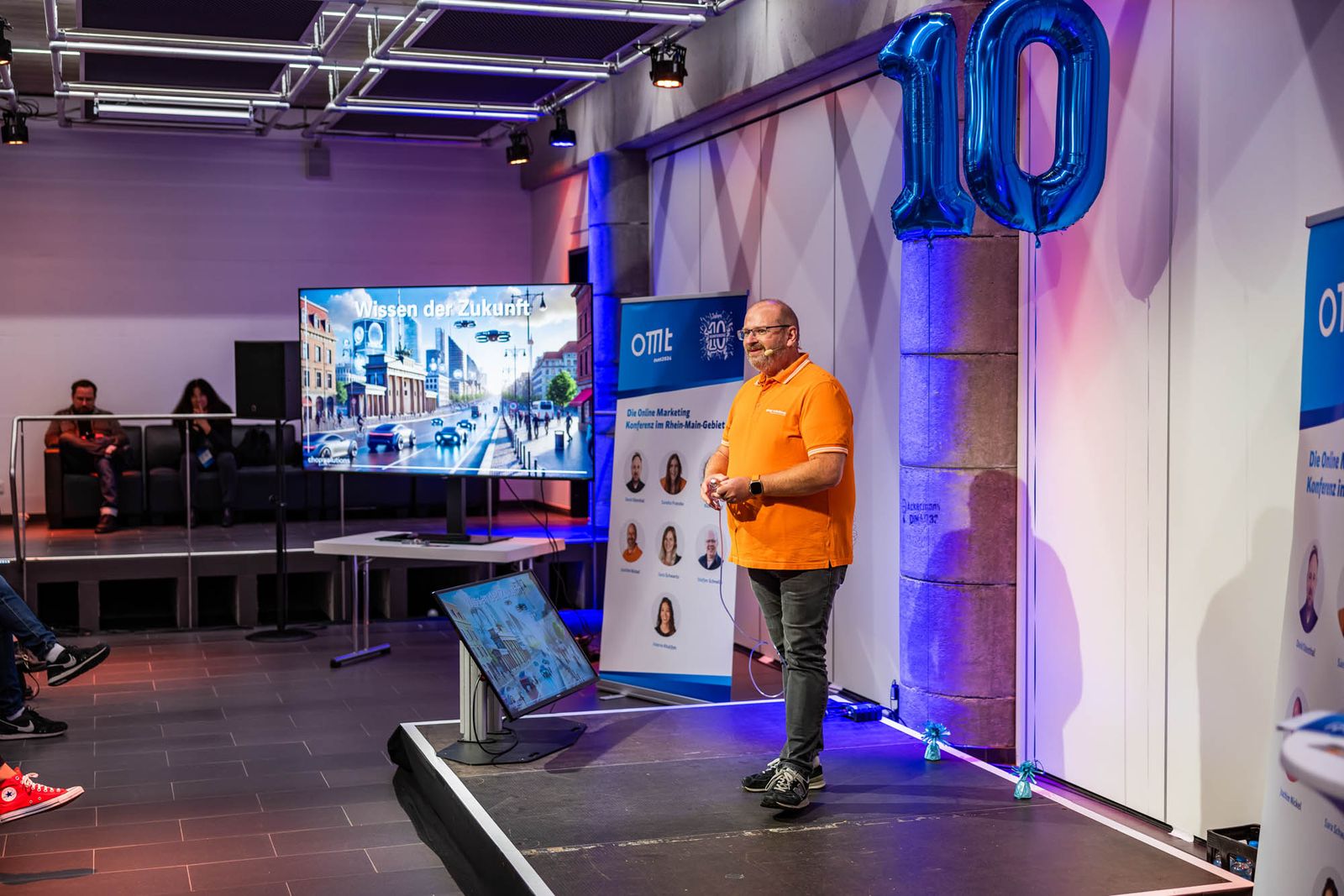 Joachim Nickel auf der Bühne der OMT-Konferenz 2024 vor einer Leinwand mit dem Titel Wissen der Zukunft